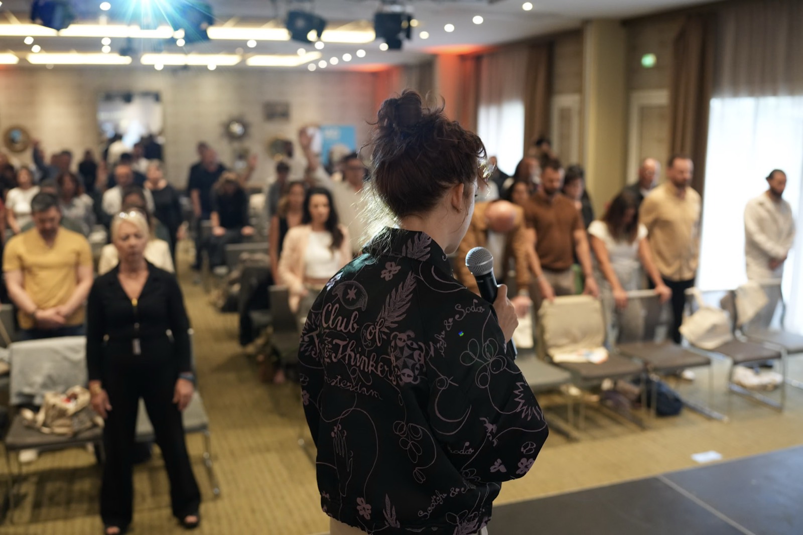 Gabriella Baert en intervention devant une salle de dirigeants debout, en exercice